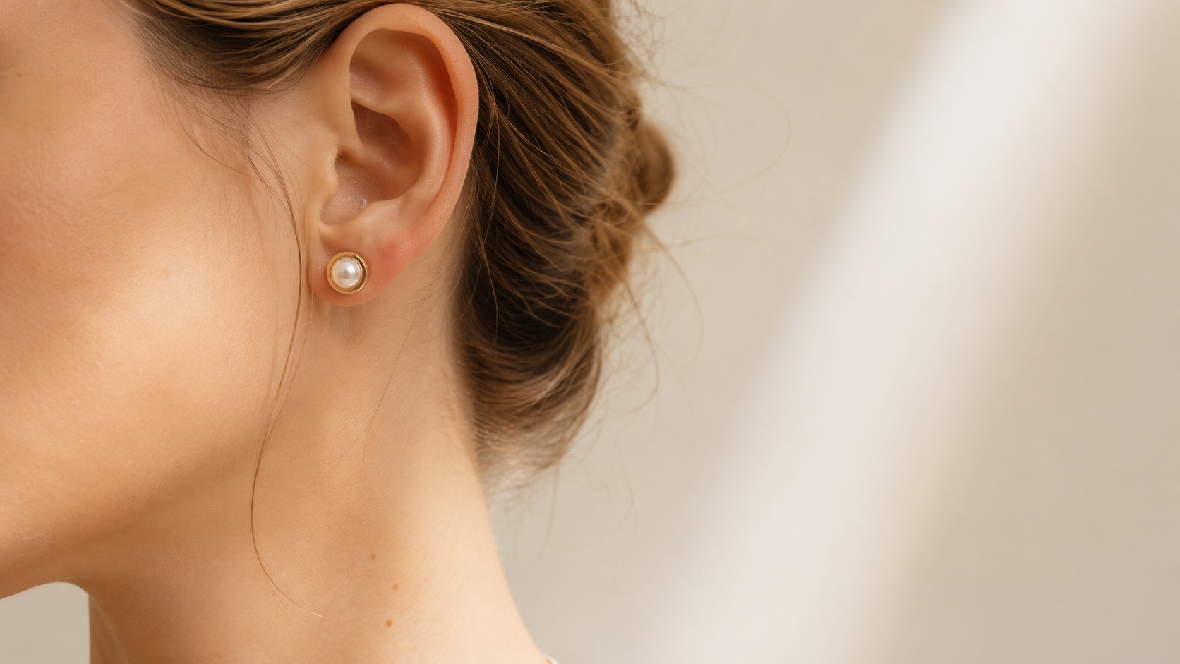 The Half Pearl worn close to the ear in soft light.